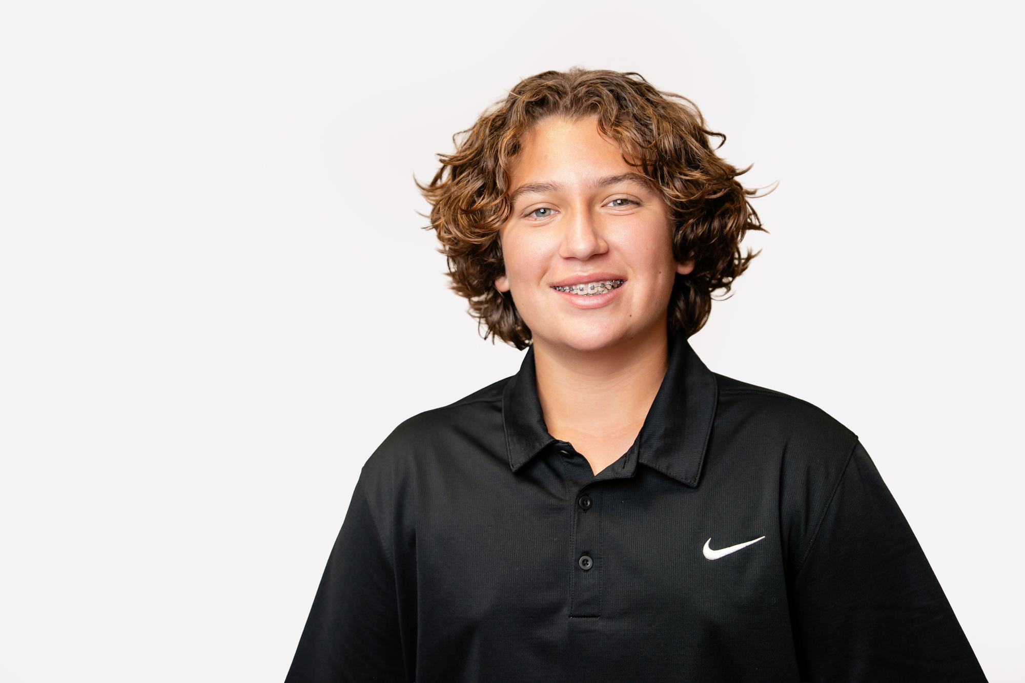 Teenager smiling with Damon metal braces for orthodontic treatment at Maui Orthodontics.
